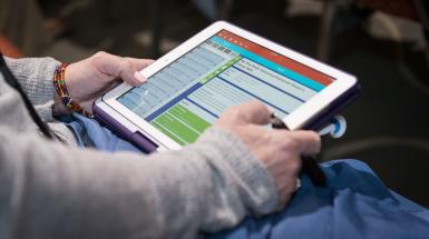 Person holding tablet, browing CEC's online all-member forum